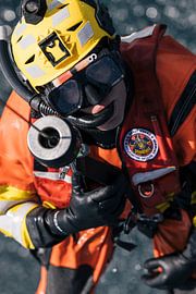 Taucher hängt aus einem Hubschrauber der Küstenwache während einer Übung über dem Meer von Jimmy van Drunen