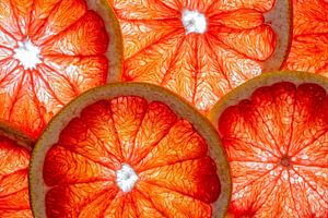 Collage aus Scheiben von Grapefruit mit weißem Hintergrund. von Carola Schellekens
