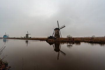 Windmolens langs het water aan de kinderdijk. van Brian Morgan