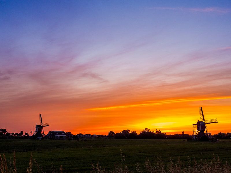 twee windmolens bij zonsopgang in Nederland. van Ruurd Dankloff