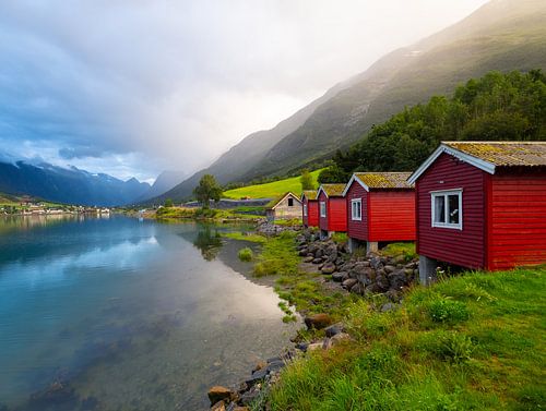 Red cabin near a cloudy fjord in Norway