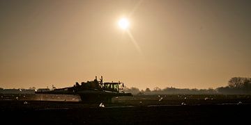 landbouw akker met tractor in avondschemering van Joost Duppen
