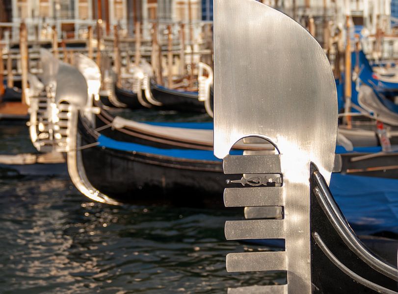 Glimmend boegstuk, de ferro, van gondels in het water van Venetië van Jan Willem de Groot Photography