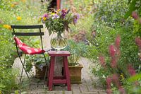 Blick in den Sommergarten mit Blumenvase