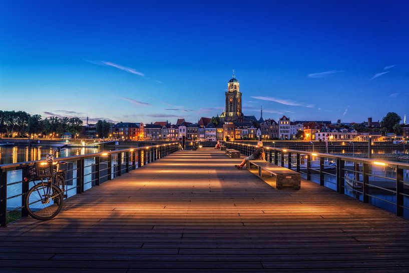 Iemand kijkt naar Deventer tijdens het blauwe uur aan de IJssel. van Bart Ros