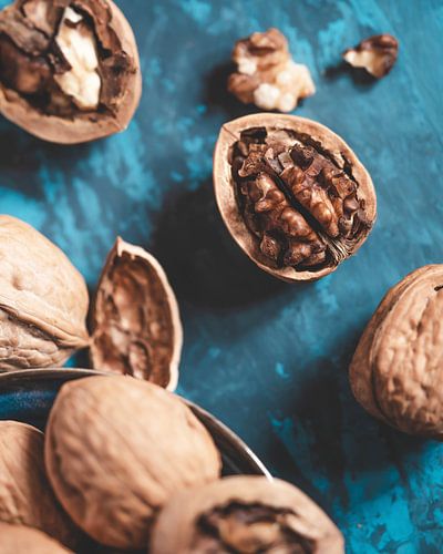 Zerbrochene Walnüsse auf einem blauen Tisch