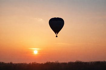 Heißluftballon bei Sonnenaufgang über dem Horizont