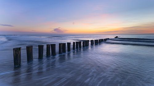 Des brise-lames en bois dans la mer au coucher du soleil – Côte de la mer du Nord à Schoorl