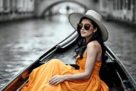 Frau in orangefarbenem Kleid in Gondel in Venedig von Jan Bouma