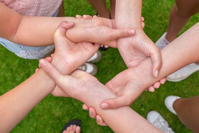 Girls hands and arms grab each other at wrists by Ben Schonewille