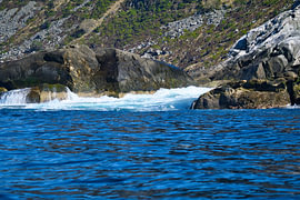Norway by the fjord, spray on the rocks. Water splashes against the stones. Coastal landscape. by Martin Köbsch