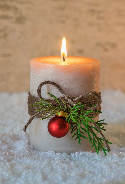 Feestelijke kerstkaars op sneeuw versierd met groene twijg van Alex Winter