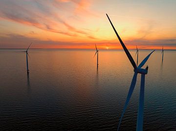 Windturbines in een offshore windpark tijdens zonsondergang