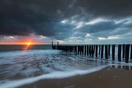 Dutch clouds and typical breakwater of wooden poles along the coast of Zeeland by gaps photography