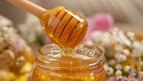 Honey in a jar with a wooden honey spoon