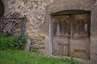 Muur oude deur wagenwiel