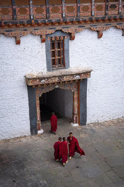 Moines bouddhistes en robe rouge dans un monastère au Bhoutan par Teun Janssen