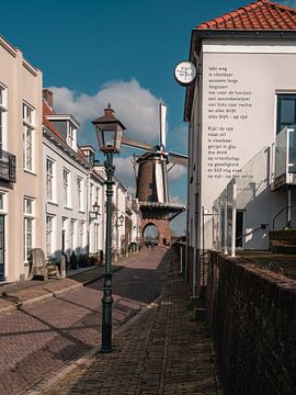 Straat in Wijk bij Duursteden met de molen op de achtergrond en een schitterend gedicht op de muur o van Jolanda Aalbers