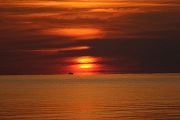 Zonsopgang over water met vissersboot