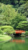 Red japanese bridge in Ritsurin Koen garden