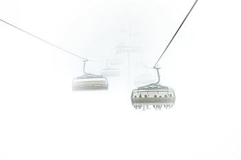 Minimalistische Schneelandschaft mit Sessellift im Nebel