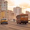 Voitures anciennes et bus scolaire au coucher du soleil à La Havane, Cuba sur Teun Janssen