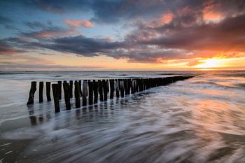 Breakwaters on the beach during sunset