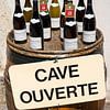 Bouteilles de vin sur un tonneau avec l'inscription 'Cave Ouverte' sur Daan Kloeg