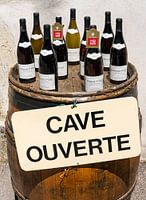 Flessen wijn op wijnvat met bord 'Cave Ouverte'