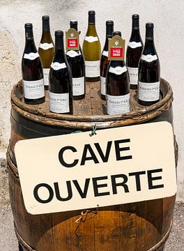 Bouteilles de vin sur un tonneau avec l'inscription 'Cave Ouverte'