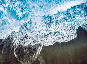 Verbrennung des blauen Meeres am schwarzen Vulkanstrand