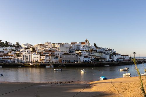 Zandstrand in de ochtend met uitzicht op het historische centrum van Ferragudo, Portimão, Algarve, Portugal