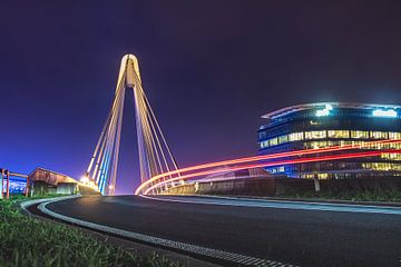 Lighttrail of a passing car at Ottergembrug with an illuminated building in the background. by Daan Duvillier | Dsquared Photography