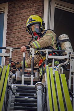 Brandweerman tijdens een inzet met de ladderwagen. van Meterfotografie