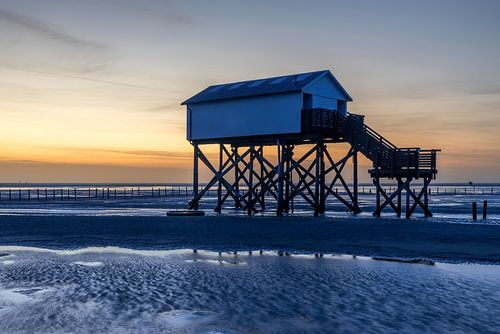 Pfahlbauten an der Nordseeküste am Strand von St. Peter Ording zum Sonnenuntergang