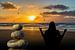 Stenen balanceren op het strand met zonsondergang en een mediterende vrouw van Animaflora PicsStock