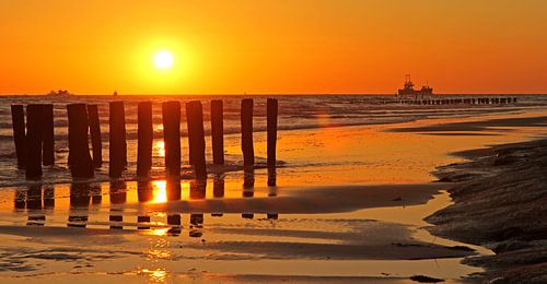 Zonsondergang achter strandpalen
