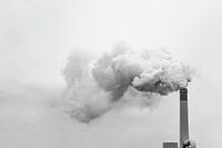 Hoge schoorsteen die rook, mist of vervuiling in de lucht afvoert