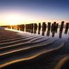 Heldere zonsondergang aan het Zeeuwse strand van Thom Brouwer