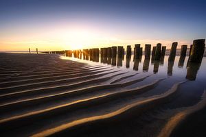 Heldere zonsondergang aan het Zeeuwse strand van Thom Brouwer