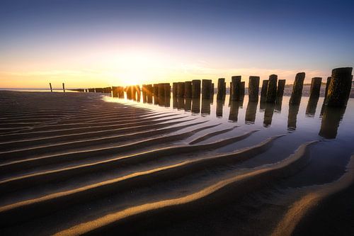 Coucher de soleil éclatant sur la plage de Zeeland sur Thom Brouwer