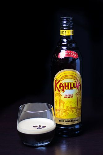 Kahlua koffiecocktail met koffiebonen als garnering tegen een zwarte achtergrond