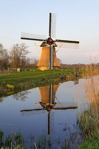 De Oudkerkermolen, in het avondlicht, weerspiegeld in de Nije Mear