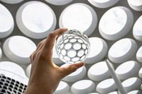 High key image of a lens ball in front of the roof over Hoog Catharijne in Utrecht