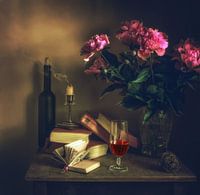 stilleven met een glas wijn, boeken en een boeket pioenrozen