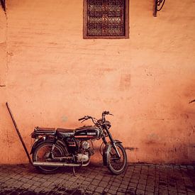Vintage brommer tegen rode muur in Marrakesh van Rob Berns