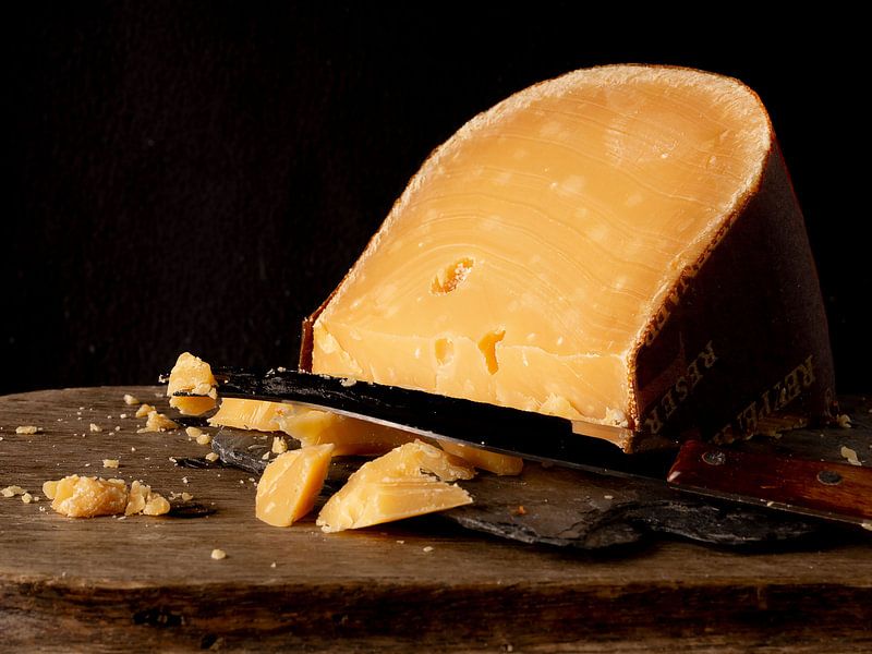 Alter zerbröckelter Käse auf Holzplanke von simone swart
