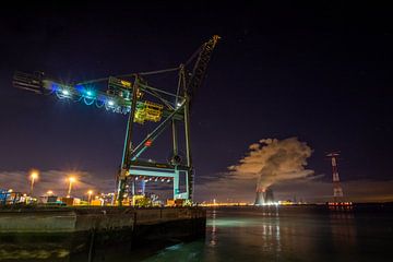 Massive port crane in the Port of Antwerp with cooling towers Doel by Daan Duvillier | Dsquared Photography