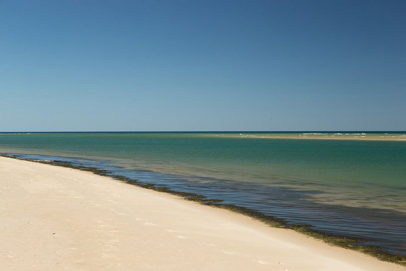 Helderwit strand met blauwe zee en lucht in Portugal van Arjan Groot