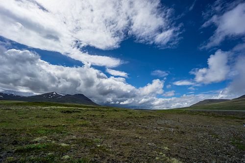 IJsland - Blauwe lucht met zon en donkere wolken met onweer
